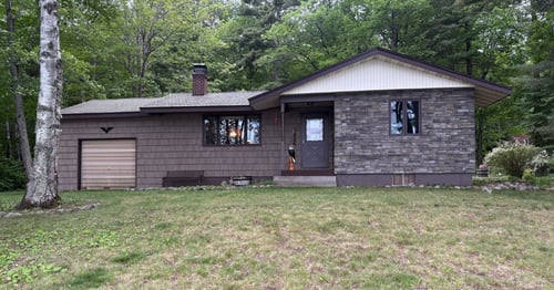 Exterior remodeling project in Couderay, WI featuring Foundry 10-inch shake siding, Versetta Stone, and Walsh windows and doors.