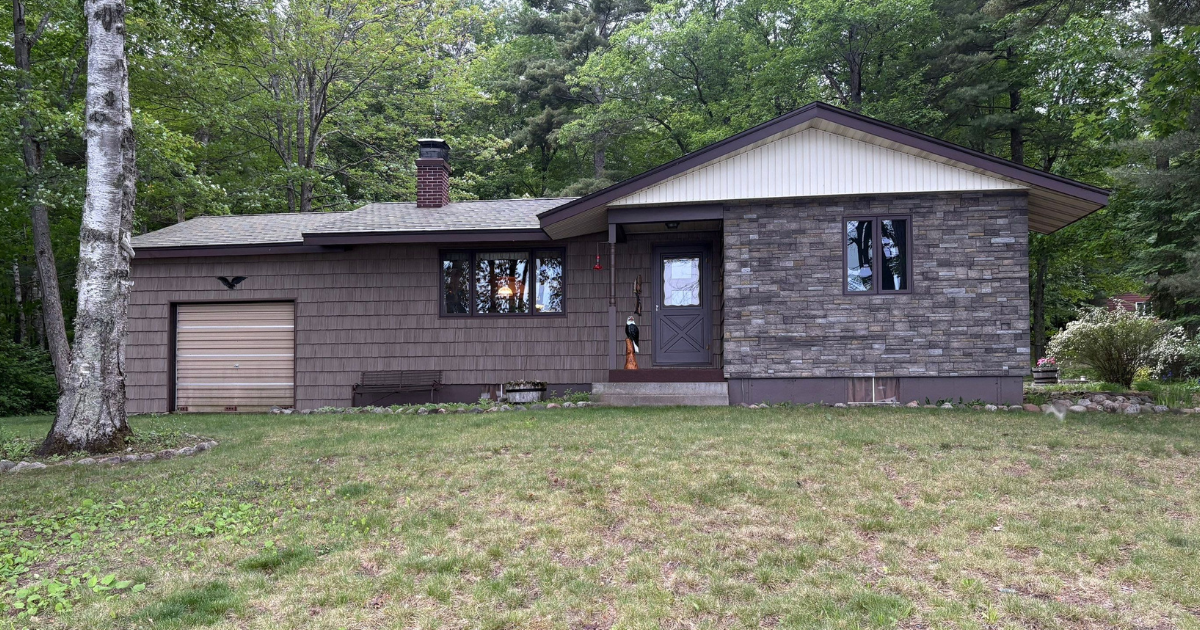 Exterior remodeling project in Couderay, WI featuring Foundry 10-inch shake siding, Versetta Stone, and Walsh windows and doors.